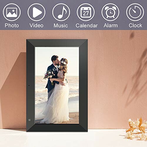 Digital photo frame displaying a couple kissing at a beach wedding.