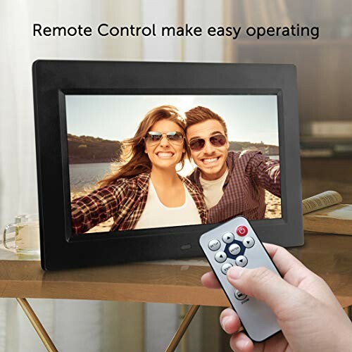 Person using a remote to control a digital photo frame displaying a couple smiling.