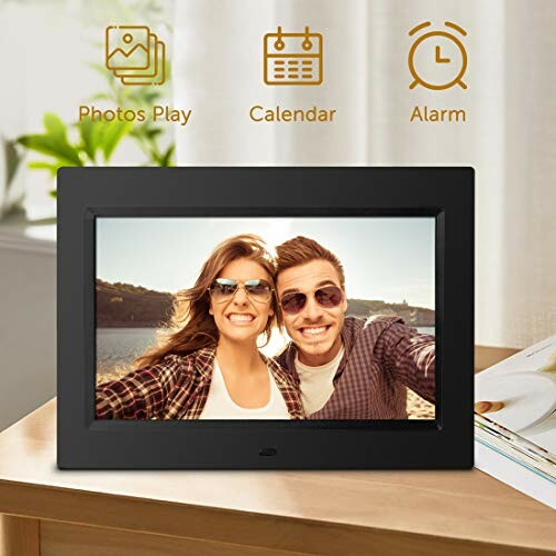 Digital photo frame with couple smiling in sunglasses.