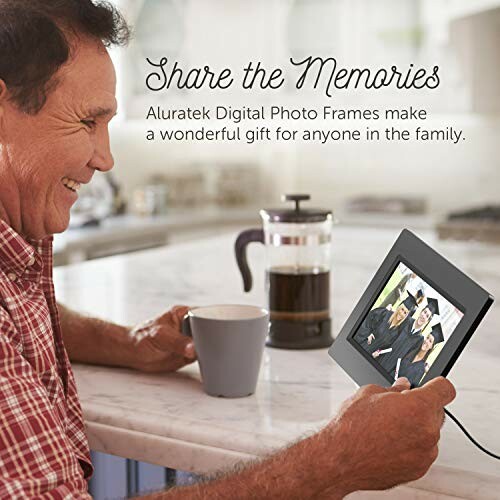 Man holding a digital photo frame at a kitchen counter with coffee.