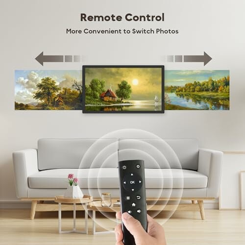 Person using remote control to switch photos on a digital frame above a sofa.